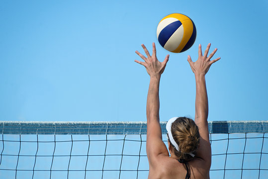Beach volleyball player jumps on the net and tries to blocks the ball