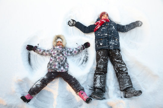 Siblings playing in a snow enjoying winter