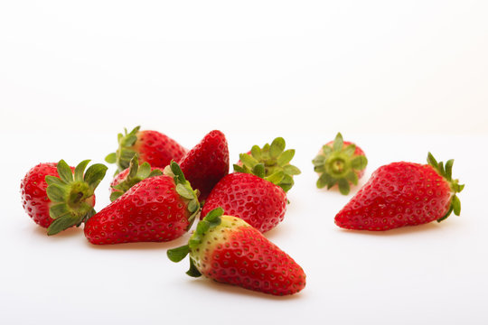 Strawberries scattered on a white background