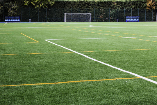 soccer field with lines painted on the grass and goal to the bot