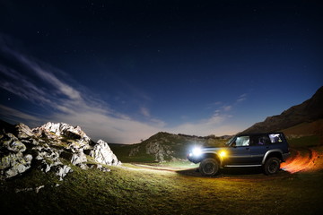 Fototapeta na wymiar Night landscape on field and terrain car