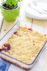 Strawberry and Raspberry Crumble on a Light Wooden Background, Vertical