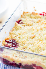 Strawberry and Raspberry Crumble on a Light Wooden Background, Vertical