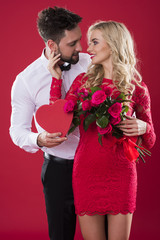 Front view of couple holding Valentine's Day symbols