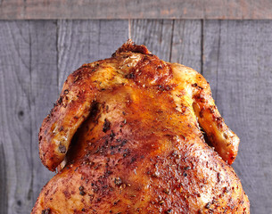 Whole roasted chicken on wooden background