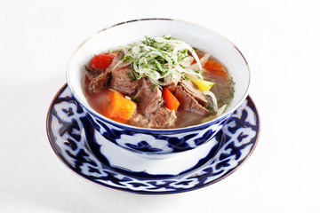 meat stew with vegetables peppers tomatoes Uzbek dish bowl  plate isolated white background