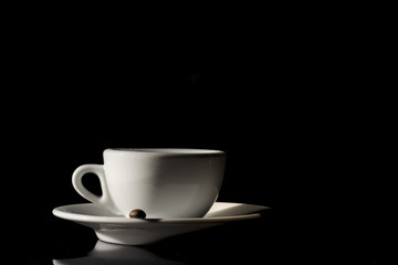 small white cup of Italian coffee on black background