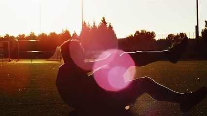 A soccer player does a bicycle kick at sunset