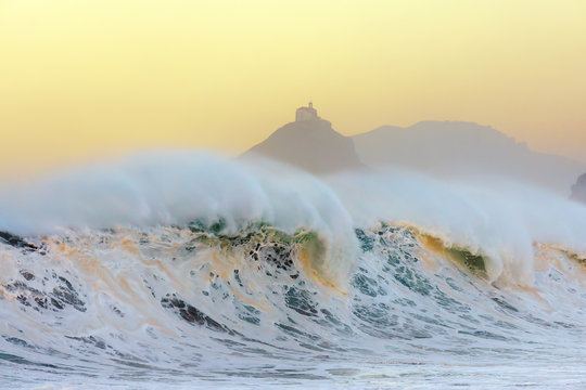 wave breaking in Bakio near gaztelugatxe at sunset