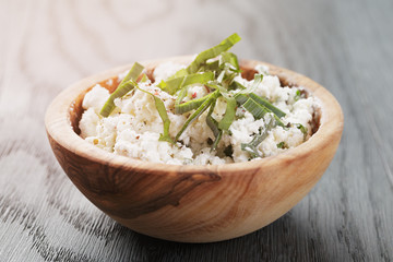 fresh ricotta with herbs in olive wood bowl