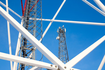 metal construction telecommunications tower against a blue sky. ladder, support towers and metal structures cell tower closeup