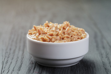 canned tuna in white bowl on wood table