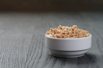 canned tuna in white bowl on wood table