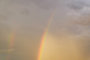 Obraz premium colorful rainbow on rain cloud sunset sky