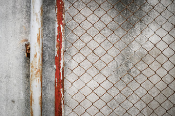 rusty iron chain wire fence on cement wall background