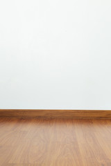 empty room with brown wood laminate floor and white mortar wall