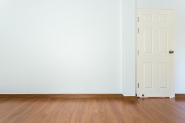empty room with brown wood laminate floor and white mortar wall