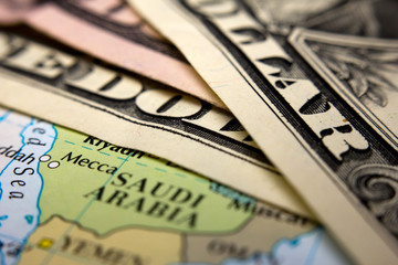 Dollar bills on top of a map of Arabia