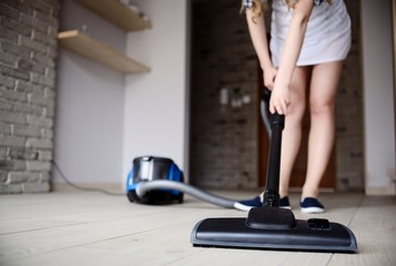Woman vacuuming the floor.