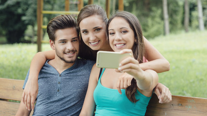 Cheerful teens at the park taking selfies