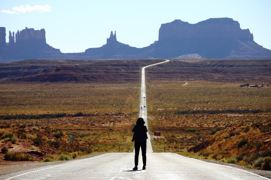 Tourist photographing the famous view from road US 163 in Monument Valley Park, Utah, USA