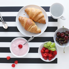 Breakfast with croissant, yoghurt and berries