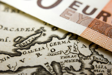 Close-up of a 50-euro banknote and an old map of Europe