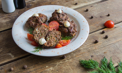 The cutlets are laid out on a white plate with dill and tomato branch.