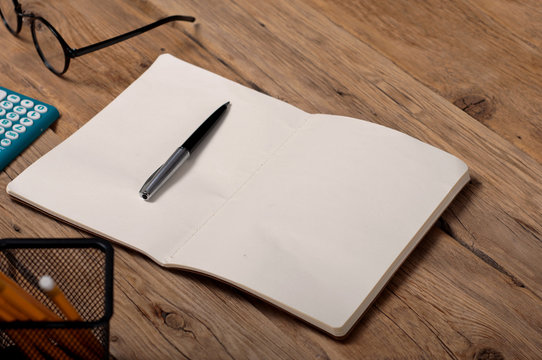 Open notebook with pen on the office table