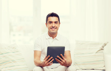 smiling man working with tablet pc at home