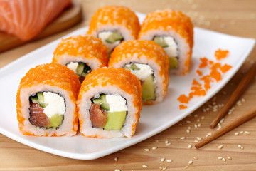 Philadelphia sushi roll with salmon, avocado, cream cheese, cucumber and tobiko caviar.