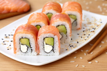 Sushi roll with smoked salmon, avocado, soft cheese and sesame seeds