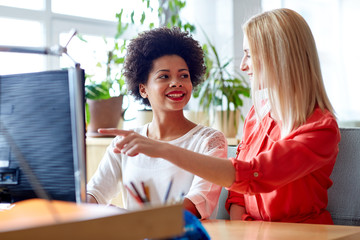 happy women or students with computer in office