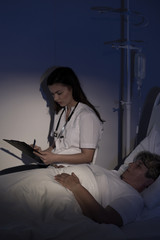 Doctor sitting by elderly patient