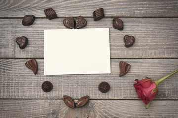 Piece of paper, chocolates and a single rose.