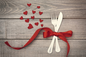 Bow of red ribbon around the silverware