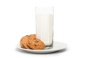Oat cookies in plate and milk in tall glass isolated on white ba