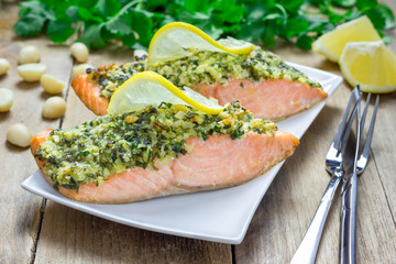 Baked salmon with macadamia-cilantro crust on a white plate