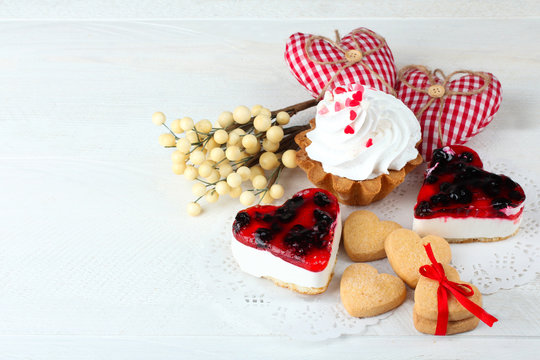 cake with jam and cookies in the shape of heart with bow on wooden table