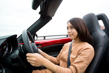 Woman driving convertible car
