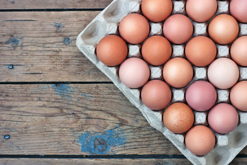 Chicken brown eggs in packing on a timber floor, the top view. F