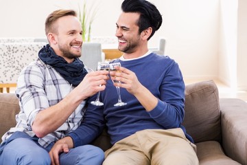 Gay couple toasting on the couch 