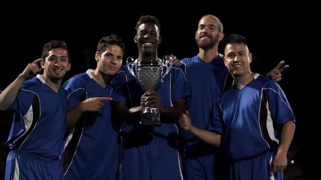A soccer team proudly holding a trophy