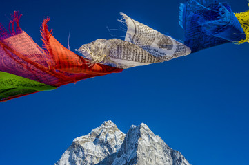 Prayer flags in the Himalayas with Ama Dablam peak in the backgr