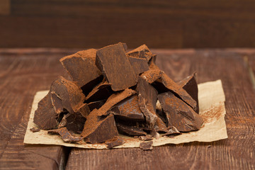 Dark chocolate with cacao on wooden table