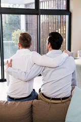 Obraz premium Rear view of gay couple with arms around 