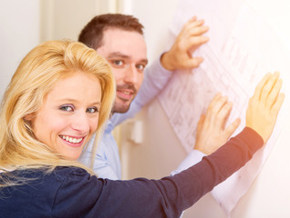 Young couple studying plans of their future house