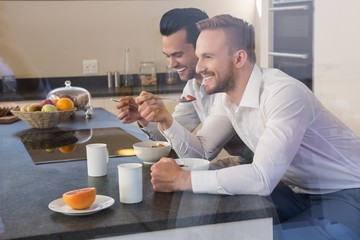 Smiling gay couple having breakfast
