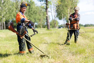 Positive landscapers men workers with gas handheld string trimmers