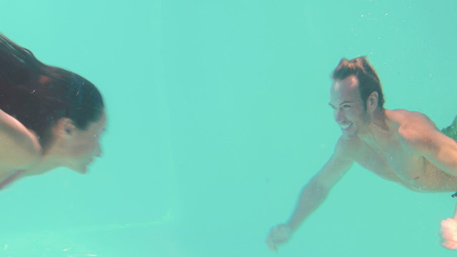 Happy couple swimming underwater